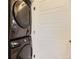 Efficient laundry space featuring a stacked washer and dryer unit next to a white paneled door at 18270 E 51St Pl, Denver, CO 80249