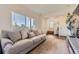 Inviting living room featuring a large window, a comfortable couch, and an open entryway leading to the staircase at 18270 E 51St Pl, Denver, CO 80249