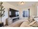 Comfortable living room with a TV, stylish entertainment center, plush couch, and sliding door to outside at 18270 E 51St Pl, Denver, CO 80249
