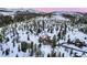 Aerial view of a luxury home surrounded by a forest and snow-covered mountains at 118 Gold Piece Dr, Breckenridge, CO 80424