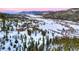 Breathtaking aerial view of the property showcasing its scenic surroundings, including mountains, a lake, and snow-covered terrain at 118 Gold Piece Dr, Breckenridge, CO 80424