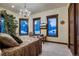 A cozy primary bedroom featuring a chandelier and scenic views from three windows at 118 Gold Piece Dr, Breckenridge, CO 80424