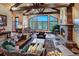 Inviting living room with stone fireplace, leather furniture, and breathtaking forest views at 118 Gold Piece Dr, Breckenridge, CO 80424