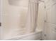 Full tub and shower combination bathroom with tile walls and a white shower curtain near the bedroom at 277 N Broadway # 202, Denver, CO 80203
