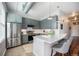 Modern kitchen with gray cabinets, stainless steel appliances, and a breakfast bar and three stools for extra seating at 277 N Broadway # 202, Denver, CO 80203