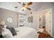 Inviting bedroom with a ceiling fan, access to a private balcony, and an ensuite bathroom with hardwood floors at 277 N Broadway # 202, Denver, CO 80203