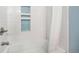 Modern bathtub with white subway tile and decorative inserts and nickel fixtures at 10247 W Roxbury Pl, Littleton, CO 80127