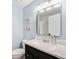 Modern bathroom vanity with a framed mirror, sleek countertop and white cabinets at 10247 W Roxbury Pl, Littleton, CO 80127