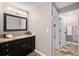 Well-appointed bathroom featuring a dark wood vanity with granite countertops, modern lighting, and tiled floors at 10247 W Roxbury Pl, Littleton, CO 80127