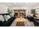 Cozy living room featuring a brick fireplace, hardwood floors, and abundant natural light at 10247 W Roxbury Pl, Littleton, CO 80127