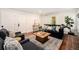 Cozy living room featuring a brick fireplace, hardwood floors, and abundant natural light at 10247 W Roxbury Pl, Littleton, CO 80127