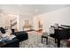 Open-concept living room with staircase access and a view of the dining area, featuring a piano and cozy seating at 10247 W Roxbury Pl, Littleton, CO 80127