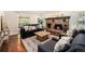 Cozy living room featuring a brick fireplace, hardwood floors, and abundant natural light at 10247 W Roxbury Pl, Littleton, CO 80127