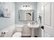 Elegant powder room with wainscoting, modern fixtures, and a decorative mirror, offering a touch of sophistication at 10247 W Roxbury Pl, Littleton, CO 80127