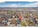 Aerial view pinpointing the property within a vibrant neighborhood and mountain backdrop at 3000 S Elati St, Englewood, CO 80110