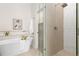 The soaking tub with wall-mounted faucet is adjacent to the glass-enclosed shower and walk-in closet at 3000 S Elati St, Englewood, CO 80110