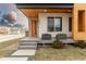 Inviting front porch with a modern design, orange door, stone accents and manicured landscaping at 3000 S Elati St, Englewood, CO 80110