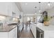 Open kitchen featuring stainless steel appliances, white cabinetry, a large island and pendant lighting at 3000 S Elati St, Englewood, CO 80110
