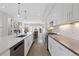 Stylish kitchen with white cabinetry, stainless steel appliances, and views into the living area at 3000 S Elati St, Englewood, CO 80110