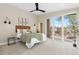 Bright, carpeted main bedroom features access to a private balcony and a modern ceiling fan at 3000 S Elati St, Englewood, CO 80110