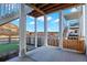 Covered patio with concrete floor looking out to a backyard, hill, and open space with views of blue sky and puffy clouds at 1044 Oleander St, Castle Rock, CO 80109
