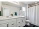 Well-lit bathroom with a spacious vanity, white cabinets, and a shower featuring a white curtain at 1044 Oleander St, Castle Rock, CO 80109