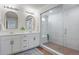 Bright bathroom features double vanity, stylish mirrors, and a walk-in shower with unique tile accents at 1044 Oleander St, Castle Rock, CO 80109