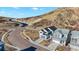 Aerial view of a home showcasing its position near a winding road, mountain landscape, and neighboring houses at 1044 Oleander St, Castle Rock, CO 80109