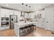 Bright kitchen with white cabinets, stainless steel appliances, an island with seating, and hardwood floors at 1044 Oleander St, Castle Rock, CO 80109