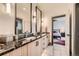 Spacious bathroom with dual sinks, granite countertop, modern fixtures, and an open doorway to the bedroom at 10689 Shadow Pines Rd, Parker, CO 80138