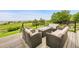 Inviting back deck seating area with woven chairs and a modern fire table with an expansive view at 26631 E Arbor Dr, Aurora, CO 80016