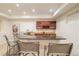 Basement bar featuring a granite countertop and custom wood cabinets with a wine rack at 26631 E Arbor Dr, Aurora, CO 80016