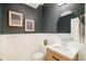 Stylish powder room features a modern vanity, round mirror, and elegant dark gray wall at 26631 E Arbor Dr, Aurora, CO 80016