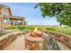 Backyard fire pit featuring stone accents and views of the lake and greenery at 26631 E Arbor Dr, Aurora, CO 80016
