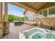 Hot tub on a wood deck featuring stylish lighting, seating, and a folding glass door at 26631 E Arbor Dr, Aurora, CO 80016