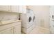 Well-equipped laundry room with modern washer and dryer, sink, and ample storage space at 26631 E Arbor Dr, Aurora, CO 80016
