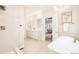 Bright bathroom featuring a double vanity, a luxurious tub, tiled floors and glass shower, exuding elegance at 26631 E Arbor Dr, Aurora, CO 80016