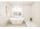 A luxurious bathroom with a modern tub, large window for natural light, and elegant tile work at 26631 E Arbor Dr, Aurora, CO 80016