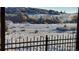 Winter's touch blankets the backyard with snow, contrasting with colorful foliage and mountain views at 7482 Sleeping Bear Trl, Littleton, CO 80125