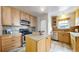 Modern kitchen with light wood cabinets, stainless steel appliances, and an island at 5035 W 32Nd Ave, Denver, CO 80212