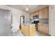 Updated kitchen with light wood cabinets, stainless steel appliances, and an island at 5035 W 32Nd Ave, Denver, CO 80212