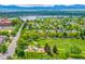 Picturesque aerial view showcasing a verdant park with a playground, framed by tree-lined streets and Sloan's Lake at 1800 Grove St, Denver, CO 80204