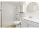 Bright bathroom featuring a shower-tub combo, modern sink with round mirror, and medicine cabinet at 1800 Grove St, Denver, CO 80204