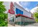 A contemporary designed Alamo Draft House Cinema with a neon sign and landscaped exterior at 1800 Grove St, Denver, CO 80204
