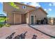 A backyard patio with brick pavers, an exterior door and trashcans, next to a brown two-story house at 3968 Ashcroft Ave, Castle Rock, CO 80104
