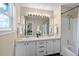 Bright bathroom featuring dual sinks, a large mirror and a shower-over-tub with a white shower curtain at 3968 Ashcroft Ave, Castle Rock, CO 80104