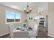 Dining area with glass table, white chairs, modern chandelier, and stainless steel appliances at 3968 Ashcroft Ave, Castle Rock, CO 80104