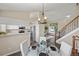 Open-concept dining area with a glass table, white chairs, and access to the living area at 3968 Ashcroft Ave, Castle Rock, CO 80104
