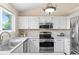 Well-lit kitchen with white cabinets, countertops, and stainless steel appliances at 3968 Ashcroft Ave, Castle Rock, CO 80104