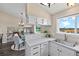 Corner of the kitchen with a window over the sink leading to dining room with a chandelier and chairs at 3968 Ashcroft Ave, Castle Rock, CO 80104